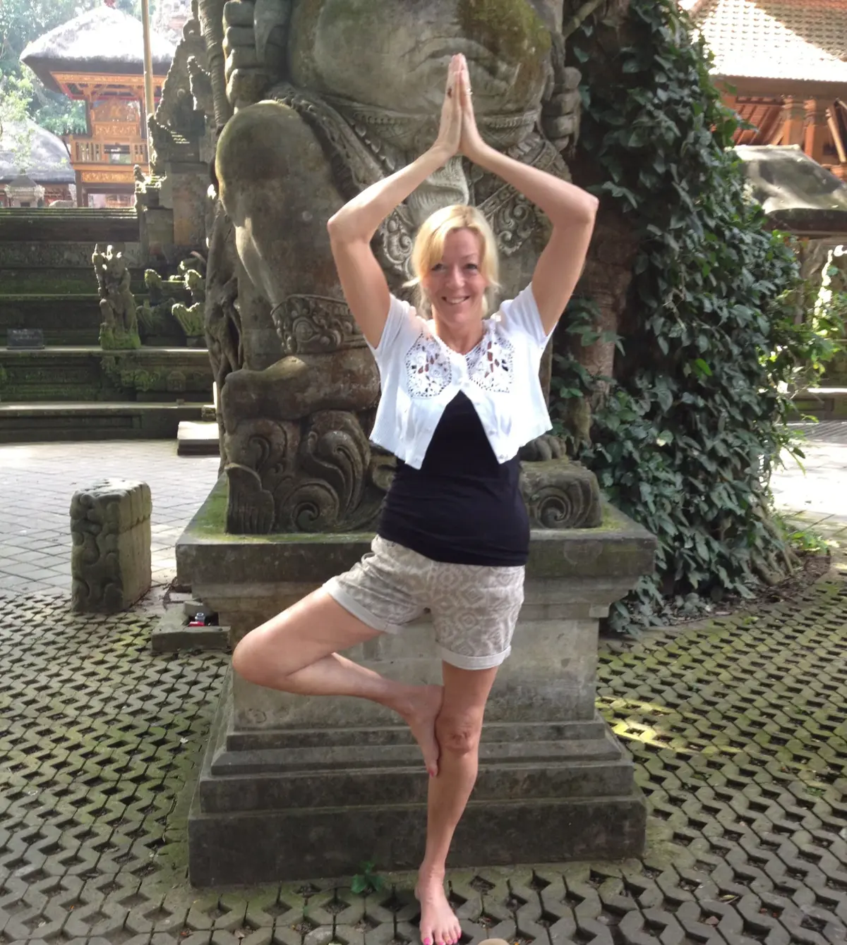 Vivien in tree pose at a stone temple