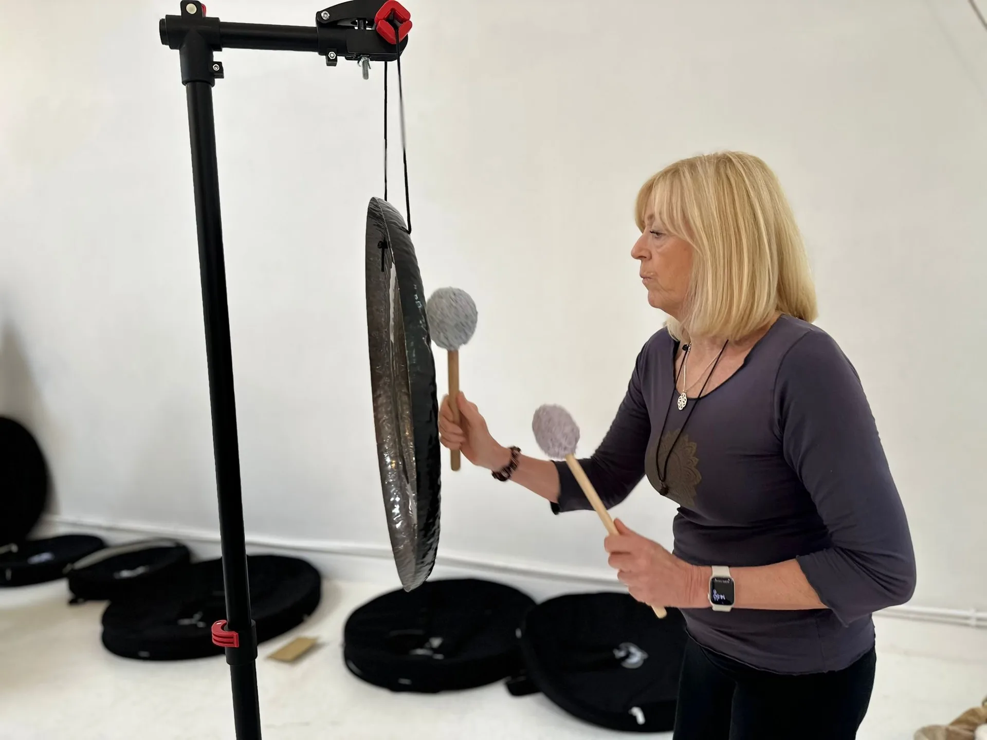 Vivien playing the gong during a sound healing session